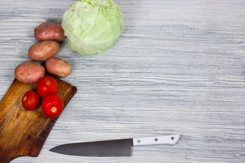 Assorted fresh vegetables with knife white wooden background Top view point. Stock Photos