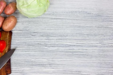 Assorted fresh vegetables with knife white wooden background Top view point. Stock Photos