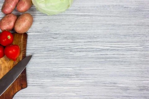 Assorted fresh vegetables with knife white wooden background Top view point. Stock Photos