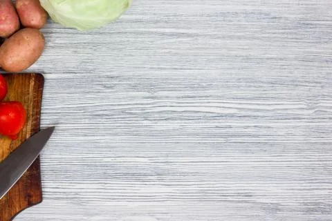 Assorted fresh vegetables with knife white wooden background Top view point. Stock Photos