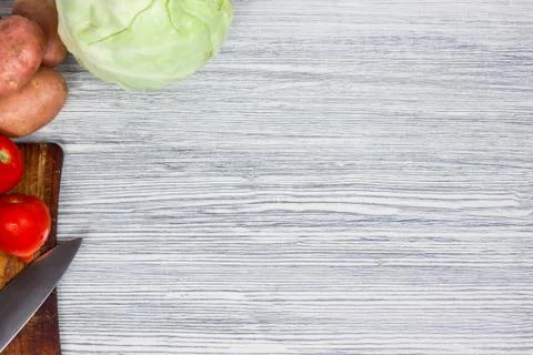 Assorted fresh vegetables with knife white wooden background Top view point. Stock Photos