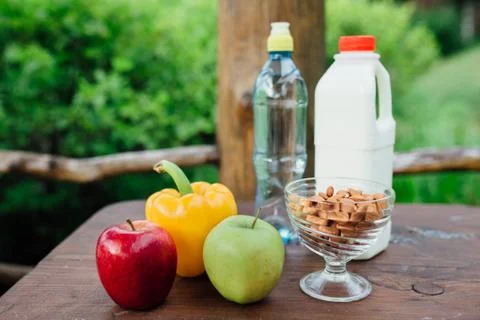 Assorted fresh vegetables, peppers, apples, water and milk on wooden table. yoga Stock Photos