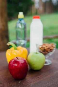 Assorted fresh vegetables, peppers, apples, water and milk on wooden table. yoga Stock Photos