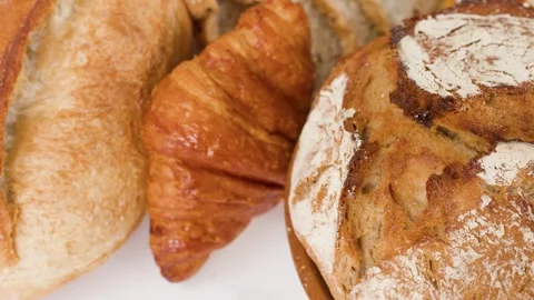 Assorted Freshly Baked Artisanal Breads and Pastries on White Background Stock Footage 337994984