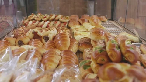 Assorted Freshly Baked Bread and Savory Pastries in Bakery Display Vídeo Stock 345967869