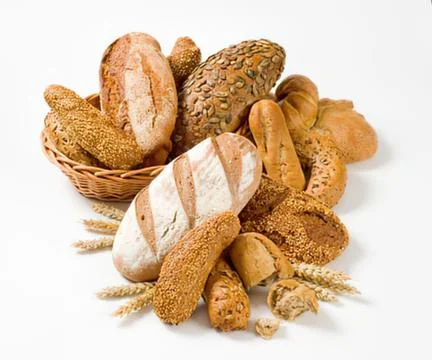 Assorted freshly baked bread loaves on wheat Stock Photos