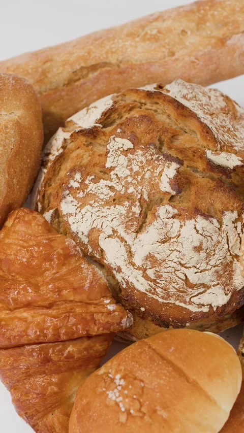 Assorted Freshly Baked Breads and Pastries on White Background Stock Footage 338051358
