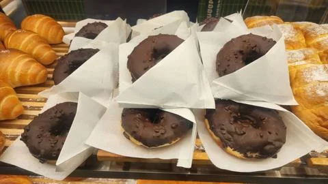 Assorted Freshly Baked Chocolate Donuts and Croissants in Bakery Shop Stock Photos