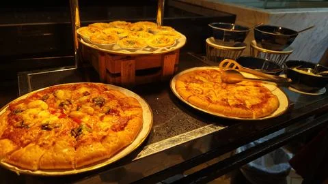 Assorted Freshly Baked Pizzas on Buffet Display at Restaurant Serving Station Stock-Fotos