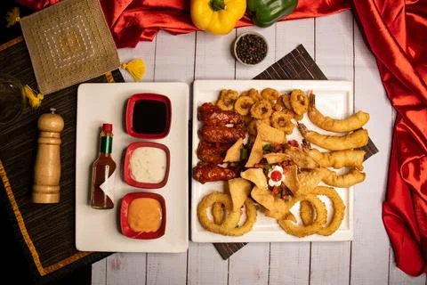 Assorted fried snacks platter with fried onion rings, shrimps, crackers, bq.. Foto stock