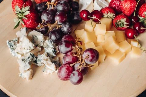 Assorted fruit and cheese plate.Close-up of delicious food plate Фото