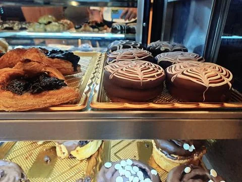 Assorted Fruit Jam Puff Pastries and Chocolate Donuts in Bakery Showcase Stock Photos