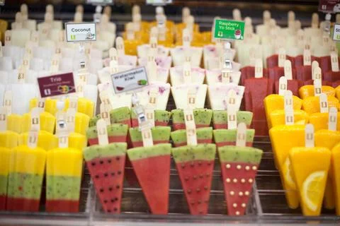 Assorted fruit popsicles standing in display freezer, artisanal frozen Stock Photos