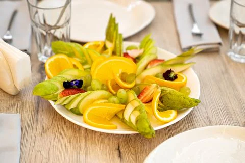 Assorted fruit slicing on a white plate on the table. Catering. Stock Photos