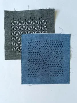 Assorted geometric sashiko embroidery patterns on textile samples. 스톡 사진