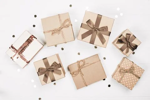 Assorted gift boxes with elegant ribbons arranged on a white wooden table Stock Photos