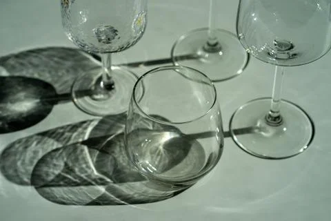 Assorted glassware for various drinks in sunlight Stock Photos
