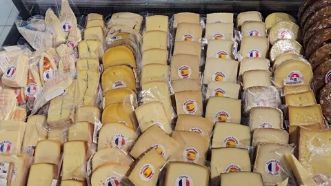 Assorted gourmet cheese blocks on display in a supermarket deli counter 스톡 동영상 334970848
