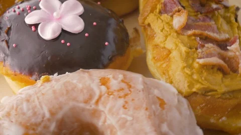 Assorted Gourmet Donuts Rotate in 4k Stock Footage 106048272