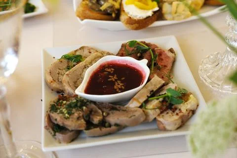 Assorted gourmet meat platter featuring sliced meats garnished with herbs Stock Photos