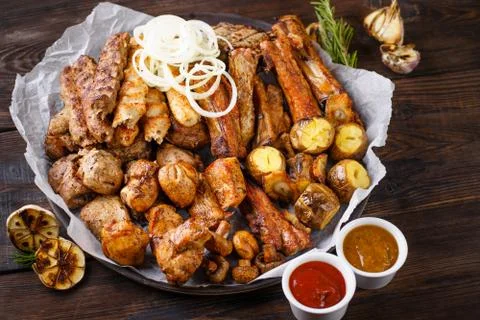 Assorted grilled meat and vegetables and bbq sauce Stock Photos