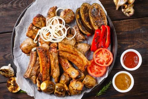Assorted grilled meat and vegetables and bbq sauce Stock Photos