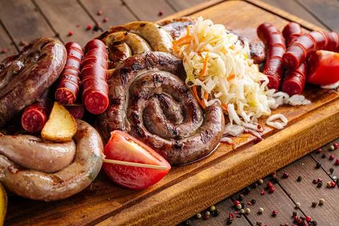 Assorted grilled sausages set on serving board Stock Photos