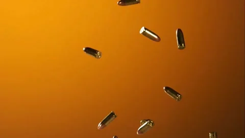 Assorted gun bullets fall through the air against a bright. Stock Footage 326756713