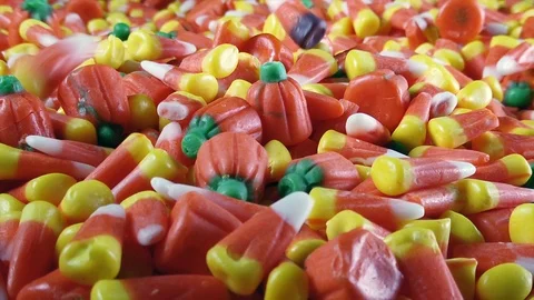 Assorted Halloween candy corn and pumpkins are seen in a large pile. Stock Footage 116573163