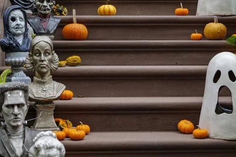 Assorted Halloween decorations guard the front steps of a house. Pumpkins on a Stock Photos