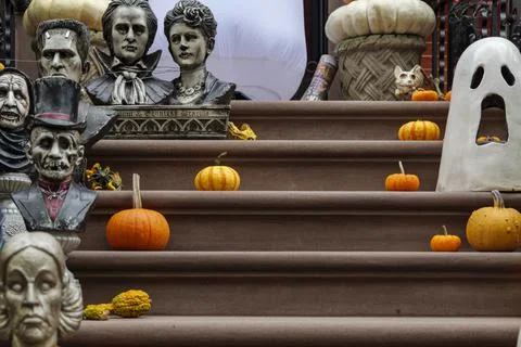 Assorted Halloween decorations guard the front steps of a house. Pumpkins on a Stock Photos
