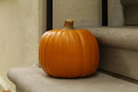 Assorted Halloween decorations guard the front steps of a house. Pumpkins on a Stock Photos