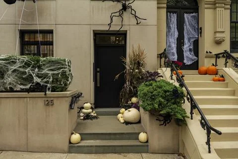 Assorted Halloween decorations guard the front steps of a house. Pumpkins on a Stock Photos