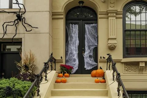 Assorted Halloween decorations guard the front steps of a house. Pumpkins on a Stock Photos