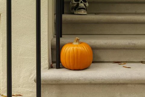 Assorted Halloween decorations guard the front steps of a house. Pumpkins on a Stock Photos