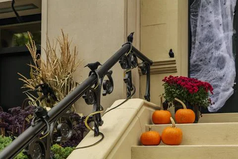 Assorted Halloween decorations guard the front steps of a house. Pumpkins on a Stock Photos