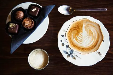 Assorted hand made chocolates A cup of coffee with foam pattern Stock Photos