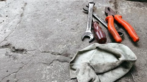 Assorted hand tools scattered across a rough cement floor with ample copy s.. Stock Photos