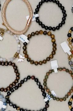 Assorted handmade bracelets displayed on a neutral fabric background Stock Photos