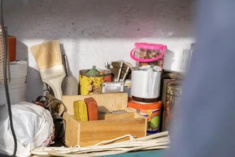 Assorted hardware and workshop supplies sit in a cluttered shelf, capturing a Stock-Fotos