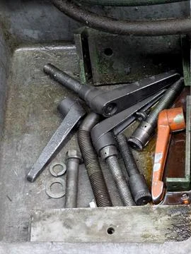 Assorted hardware inside weathered metal toolbox for repair and workshop use, 2 Stock Photos