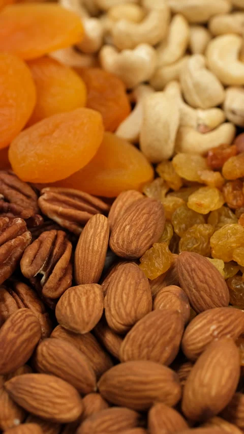 Assorted heap of different nuts and dried fruits top view, rotation Video stock 312682611