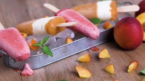 Assorted Homemade Fruit Popsicles with Fresh Peaches and Mint on Ice Stock Photos