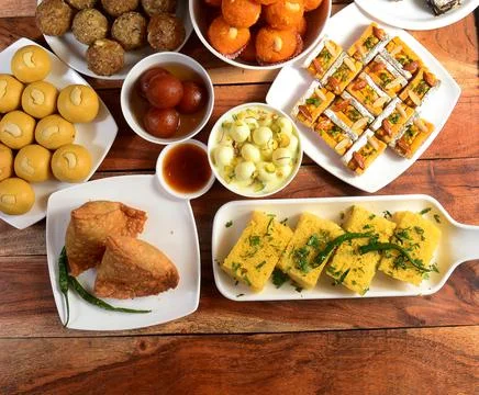 Assorted indian sweets and snacks samosa,dhokla,mysorepak,gulab jamun,rasgull Stock Photos