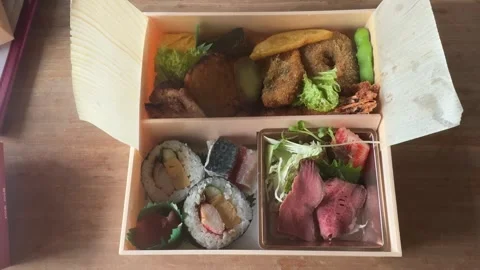 Assorted Japanese bento box with roast beef and sushi rolls, top view, Japan Stock-Footage 343348291