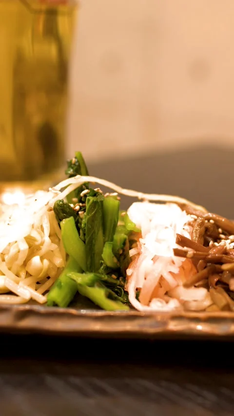 Assorted Japanese Namul Appetizer Plate with Beer in Background Stock Footage 336226181