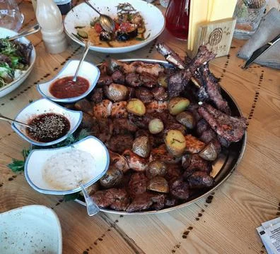 Assorted kebabs with potatoes on a plate. Stock Illustration