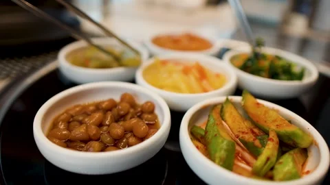 Assorted Korean Banchan Side Dishes Served in Small White Bowls Stock Footage 335359681