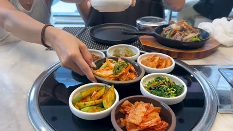 Assorted Korean Banchan Side Dishes Arranged on a Restaurant Table Stock Footage 335507772