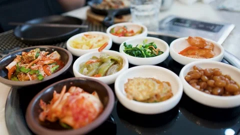 Assorted Korean Banchan Side Dishes Served in a Restaurant Setting Stock Footage 336524359